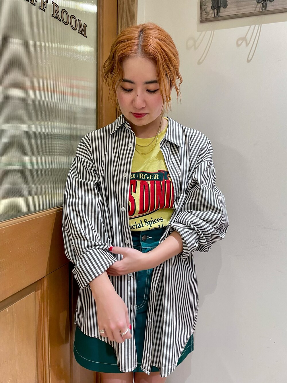 ブラック系のシャツ/ブラウス、イエロー系のTシャツ/カットソー、グリーン系のスカートを着用したレディースの春コーディネートの2枚目の写真