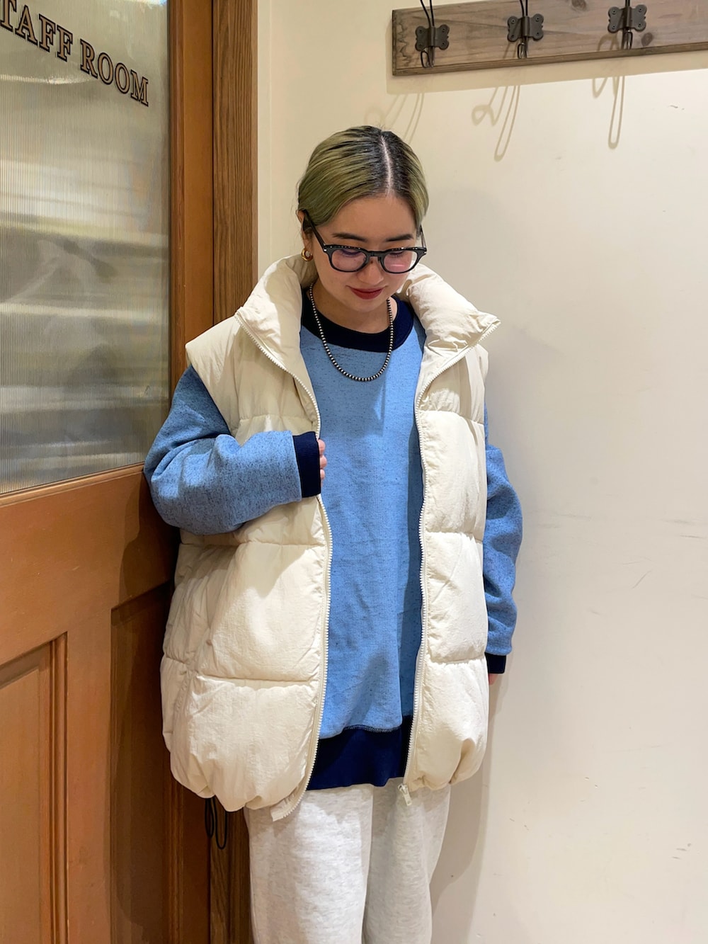 ホワイト系のダウンベスト、ブルー系のニット/セーターを着用したレディースの秋コーディネートの3枚目の写真