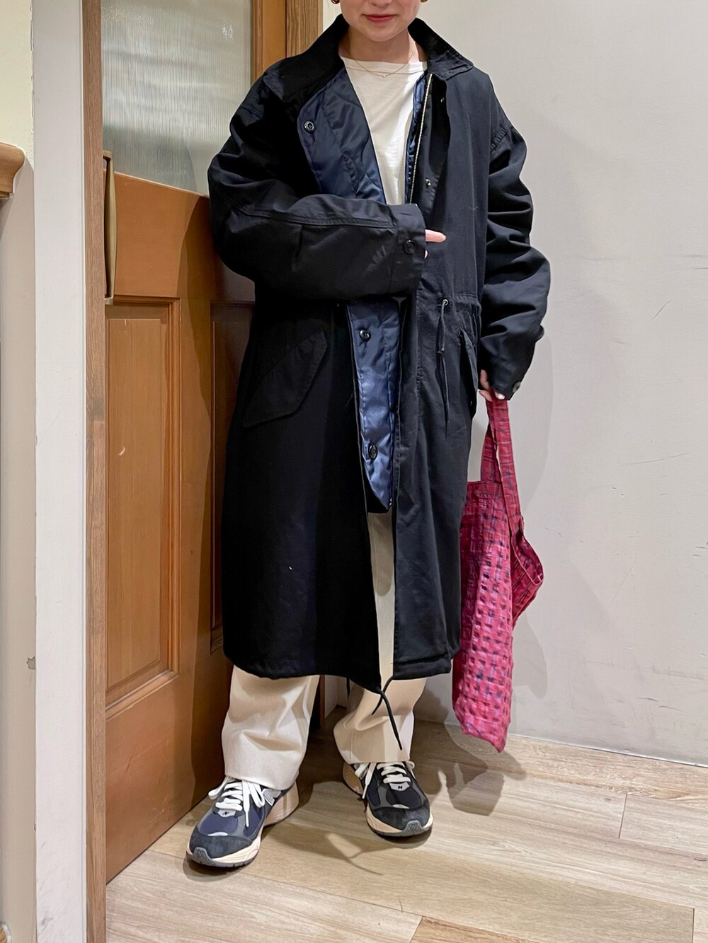 ブラック系のモッズコート、ピンク系のトートバッグを着用したレディースの秋コーディネートの3枚目の写真