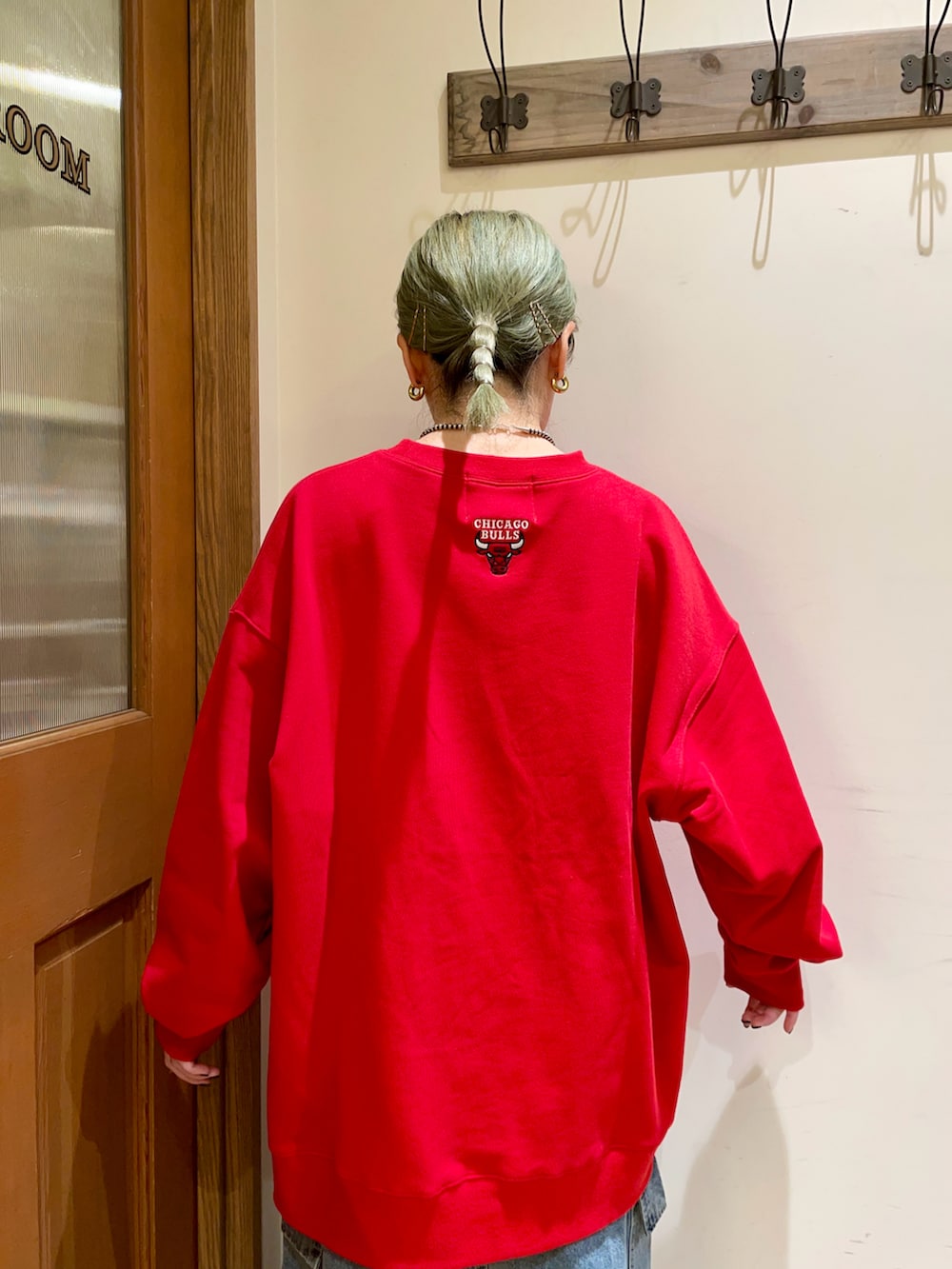 レッド系のスウェット、ブルー系のスカート、ブラック系のハンドバッグを着用したレディースの秋コーディネートの4枚目の写真