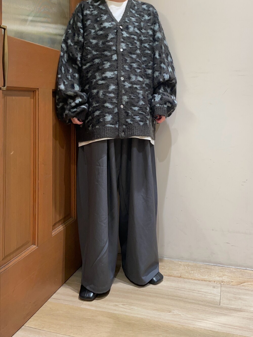 ベージュ系のカーディガン/ボレロ、グレー系のスラックス、ブラック系のハンドバッグを着用したレディースの秋コーディネートの4枚目の写真