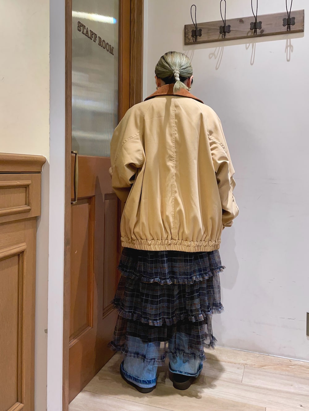 イエロー系のその他アウター、ブルー系のニット/セーター、ブラック系のスカートを着用したレディースの秋コーディネートの2枚目の写真