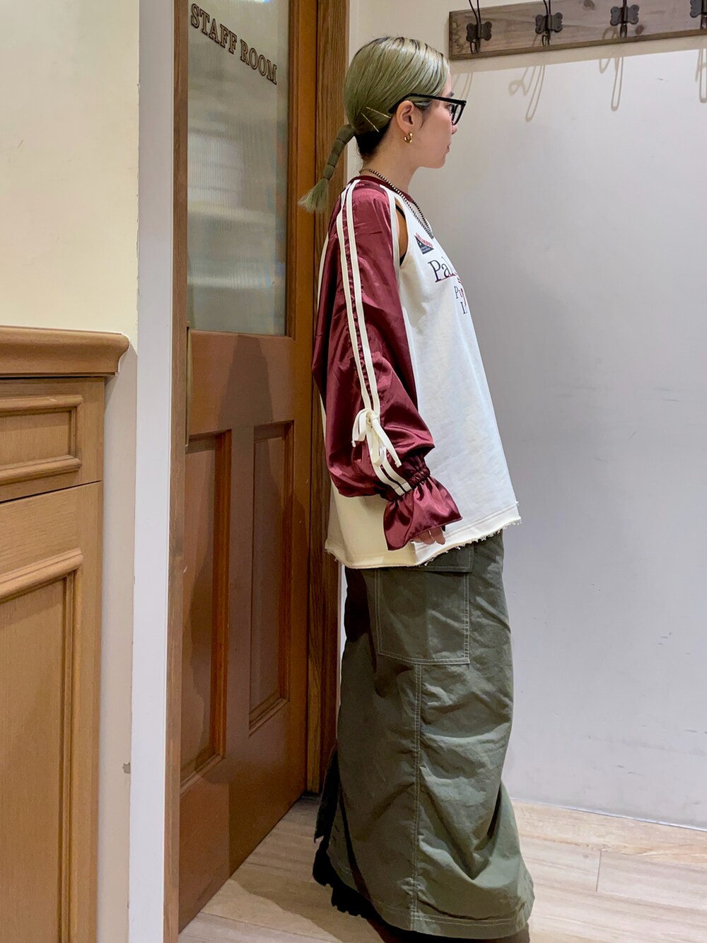 レッド系のTシャツ/カットソー、グリーン系のスカートを着用したレディースの秋コーディネートの2枚目の写真