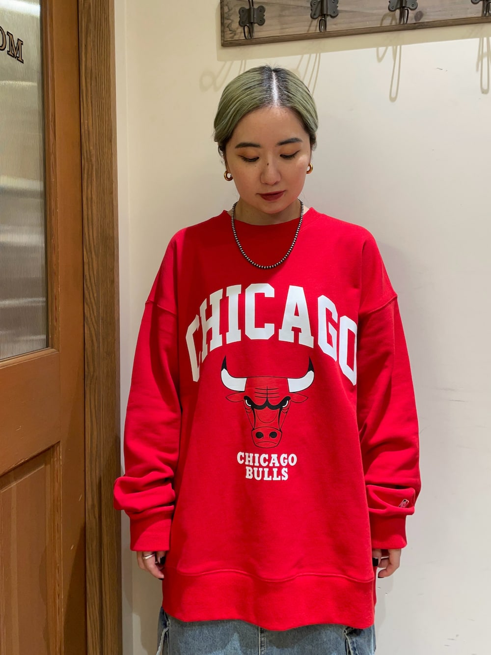 レッド系のスウェット、ブルー系のスカート、ブラック系のハンドバッグを着用したレディースの秋コーディネートの3枚目の写真