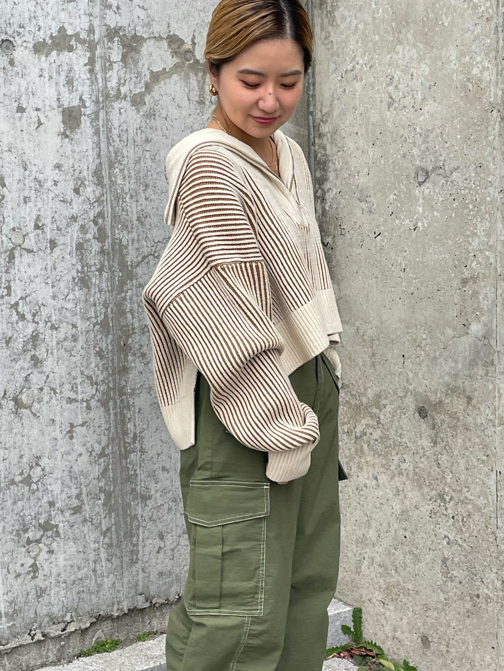 ベージュ系のニット/セーター、グリーン系のカーゴパンツ、ブラック系のブーツを着用したレディースの秋コーディネートの4枚目の写真