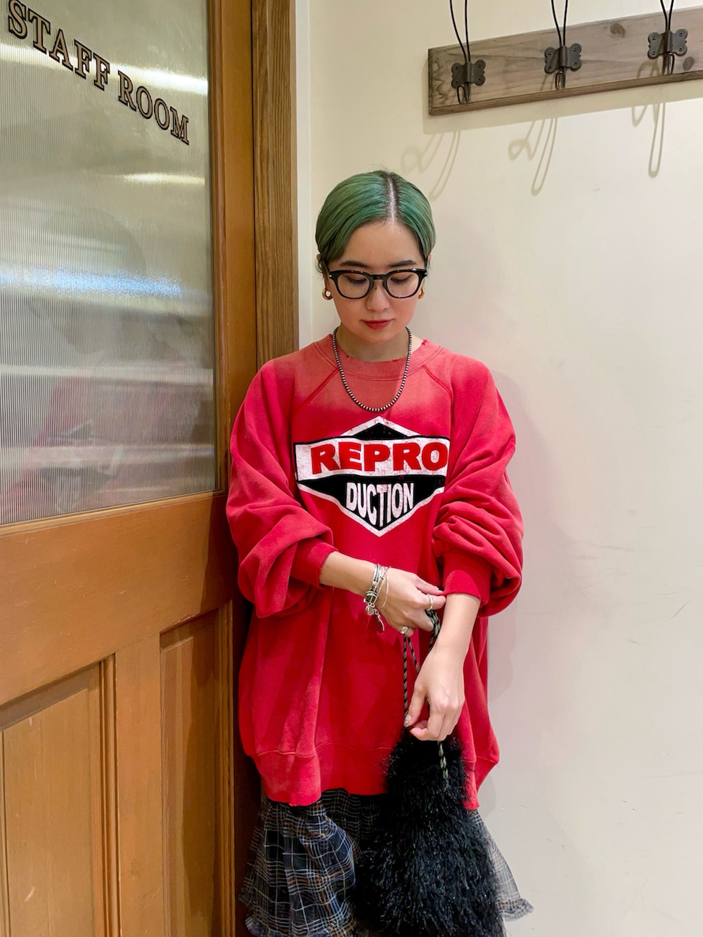 レッド系のトップス、ブラック系のスカートを着用したレディースの秋コーディネートの3枚目の写真