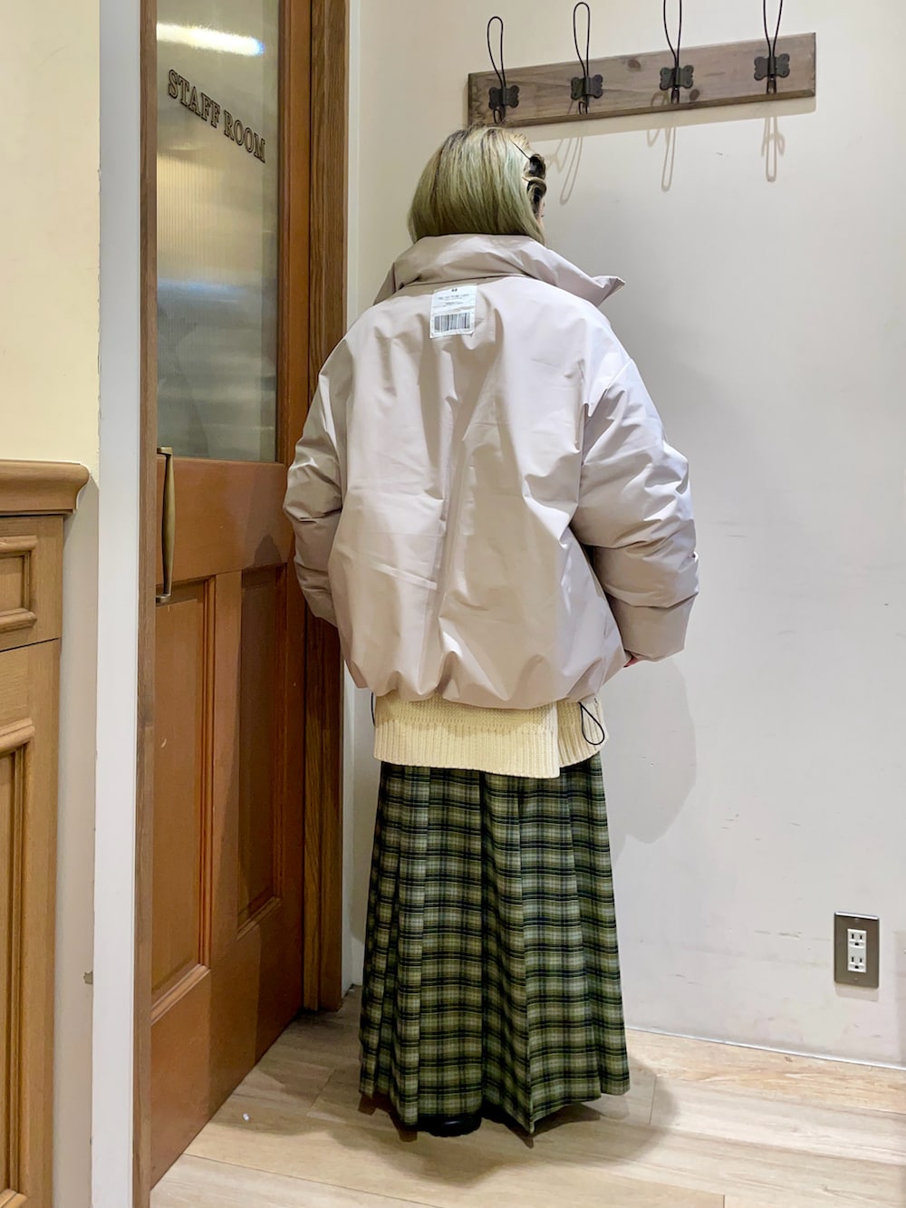 ホワイト系のニット/セーター、グレー系のダウンジャケット/コート、グリーン系のスカートを着用したレディースの冬コーディネートの2枚目の写真