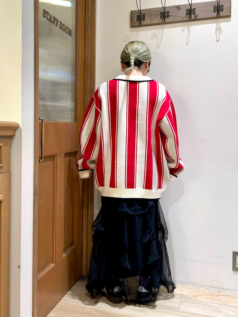 グリーン系のバックパック/リュック、ブラック系のスカート、レッド系のニット/セーターを着用したレディースの秋コーディネートの2枚目の写真