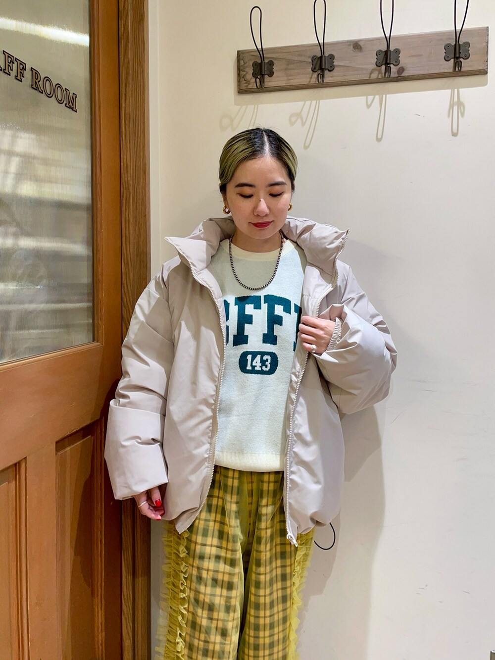 ホワイト系のダウンジャケット/コート、ホワイト系のニット/セーター、イエロー系のその他パンツを着用したレディースの秋コーディネートの3枚目の写真