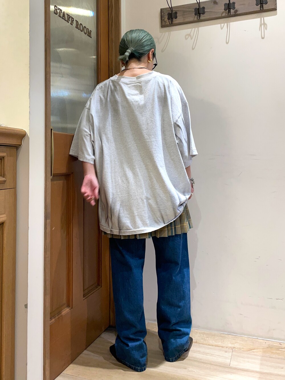 グレー系のTシャツ/カットソー、ブルー系のデニムパンツを着用したレディースの秋コーディネートの4枚目の写真