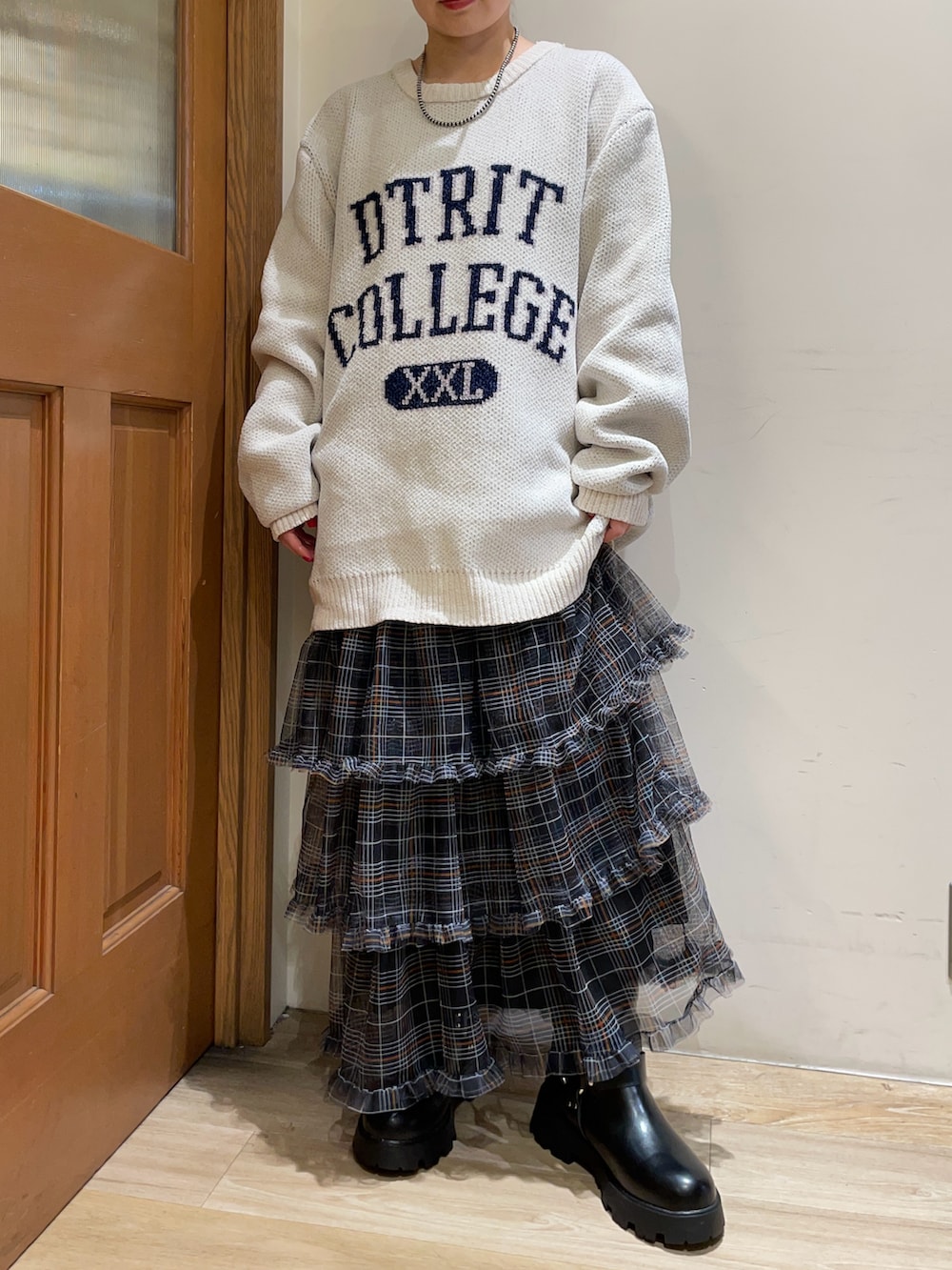 ホワイト系のニット/セーター、グリーン系のバックパック/リュック、ブラック系のスカートを着用したレディースの秋コーディネートの4枚目の写真