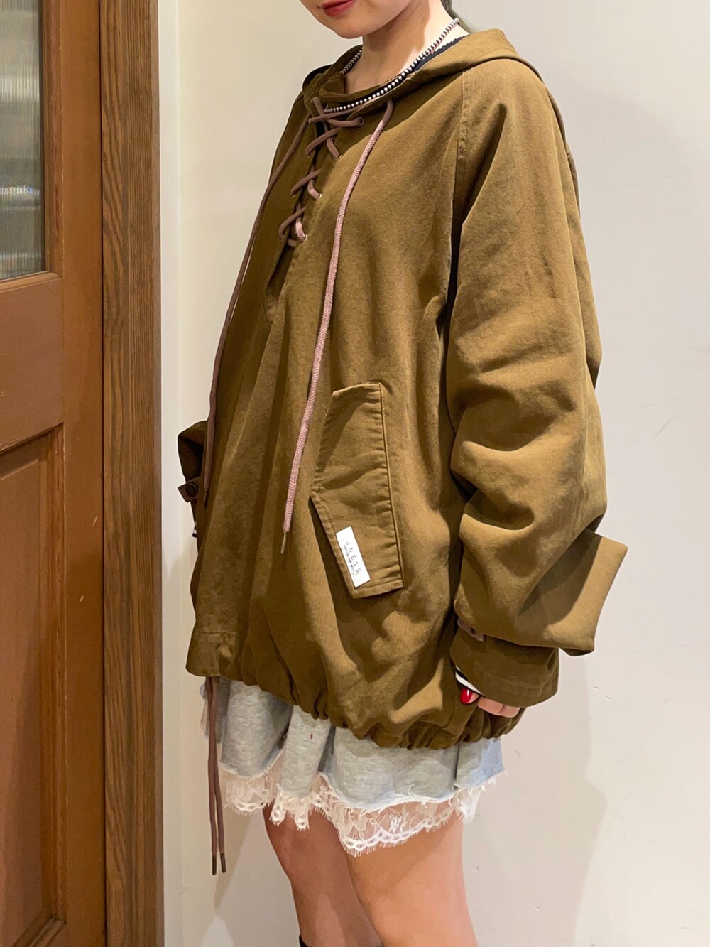 グリーン系のブルゾン、ブルー系のTシャツ/カットソー、グレー系のスカートを着用したレディースの秋コーディネートの4枚目の写真