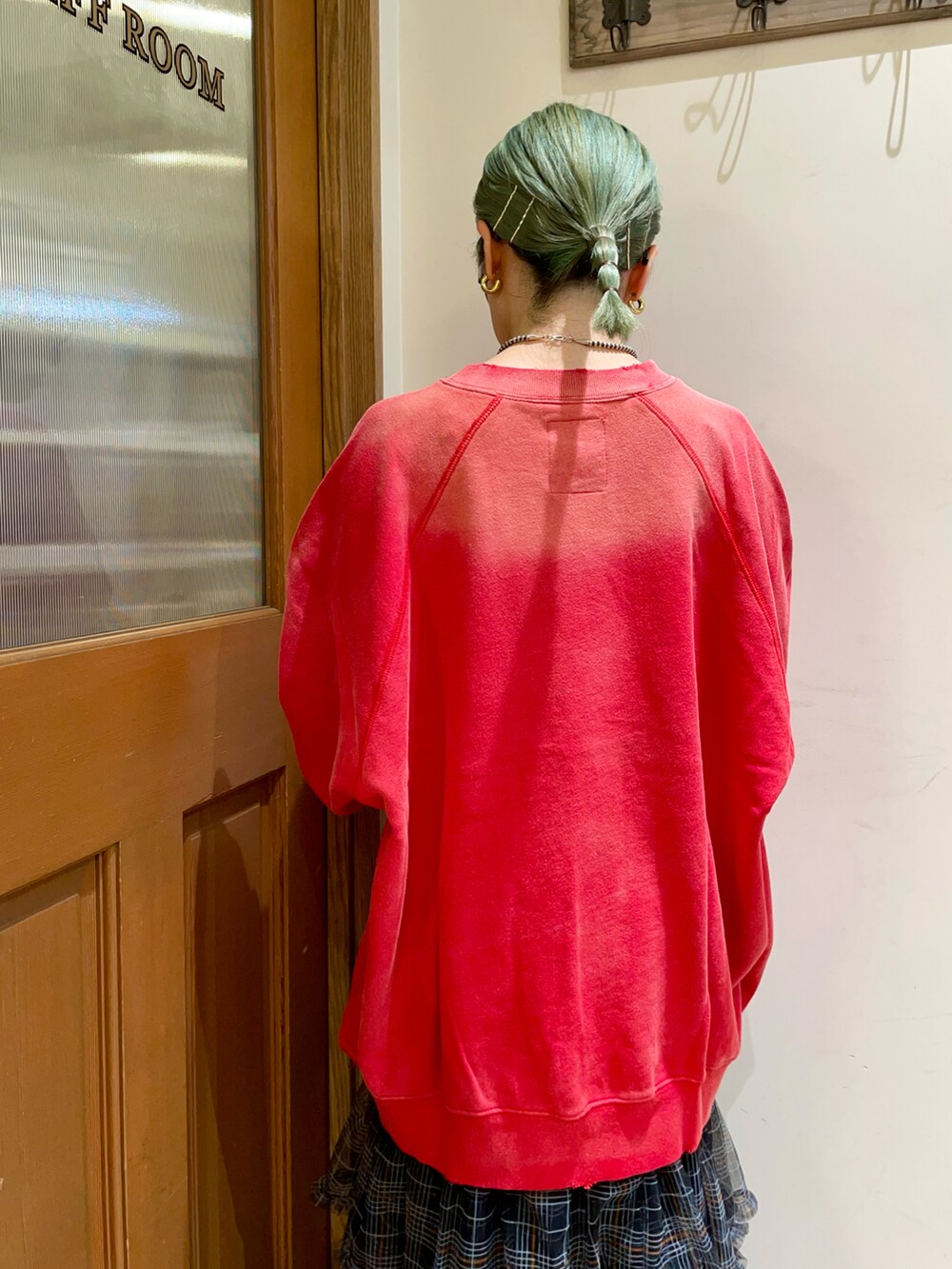 レッド系のトップス、ブラック系のスカートを着用したレディースの秋コーディネートの4枚目の写真