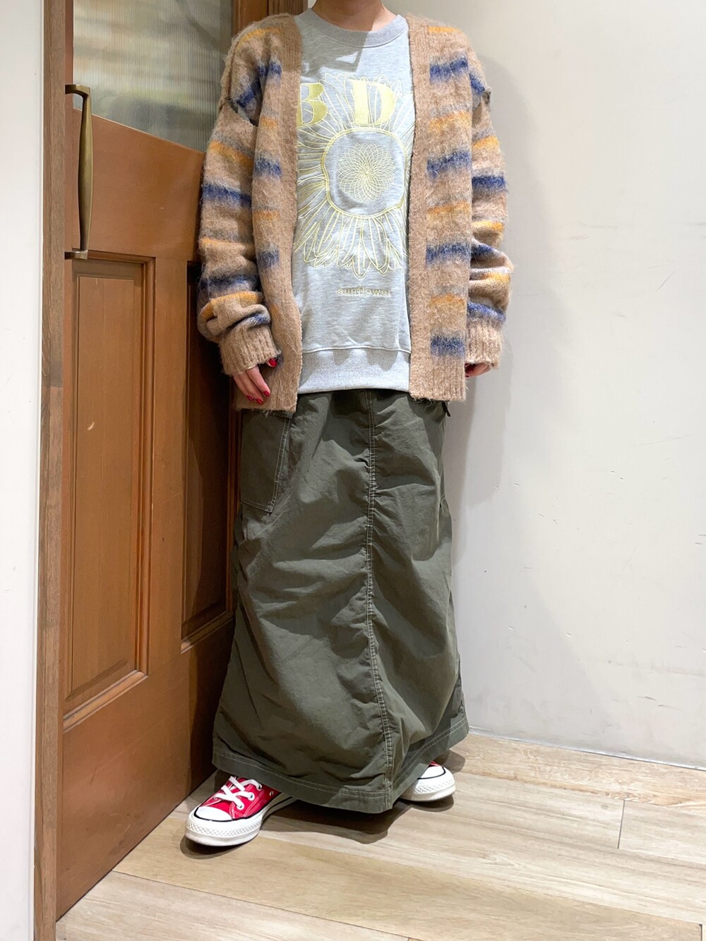 ベージュ系のカーディガン/ボレロ、グレー系のスウェット、グリーン系のスカートを着用したレディースの秋コーディネートの5枚目の写真