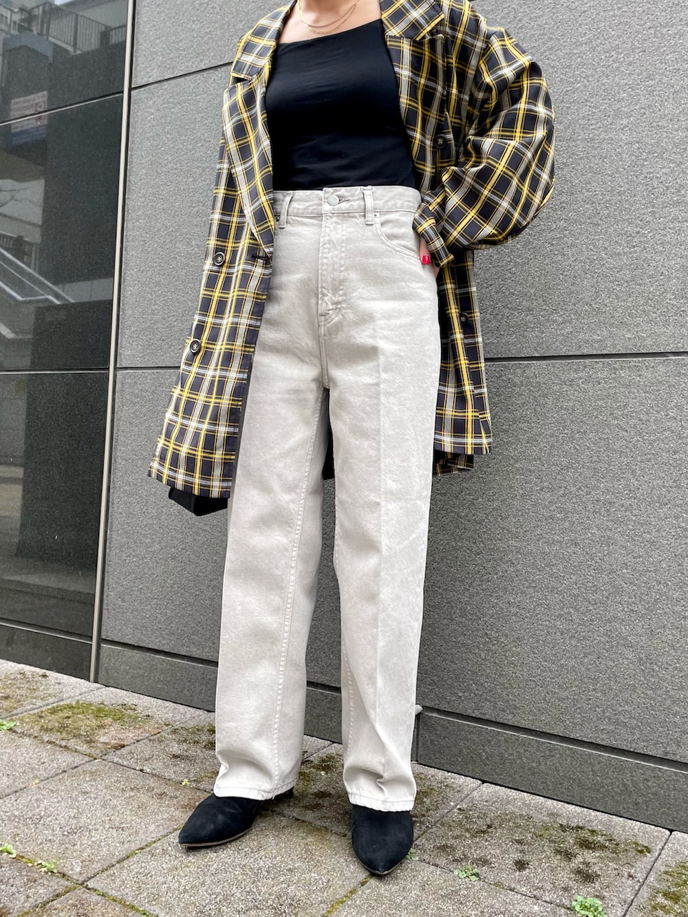 ブラック系のテーラードジャケット、ブラック系のハンドバッグ、グレー系のデニムパンツを着用したレディースの春コーディネートの4枚目の写真