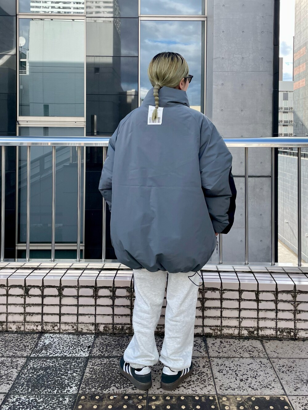 グレー系のダウンジャケット/コート、ホワイト系のニット/セーターを着用したレディースの秋コーディネートの2枚目の写真