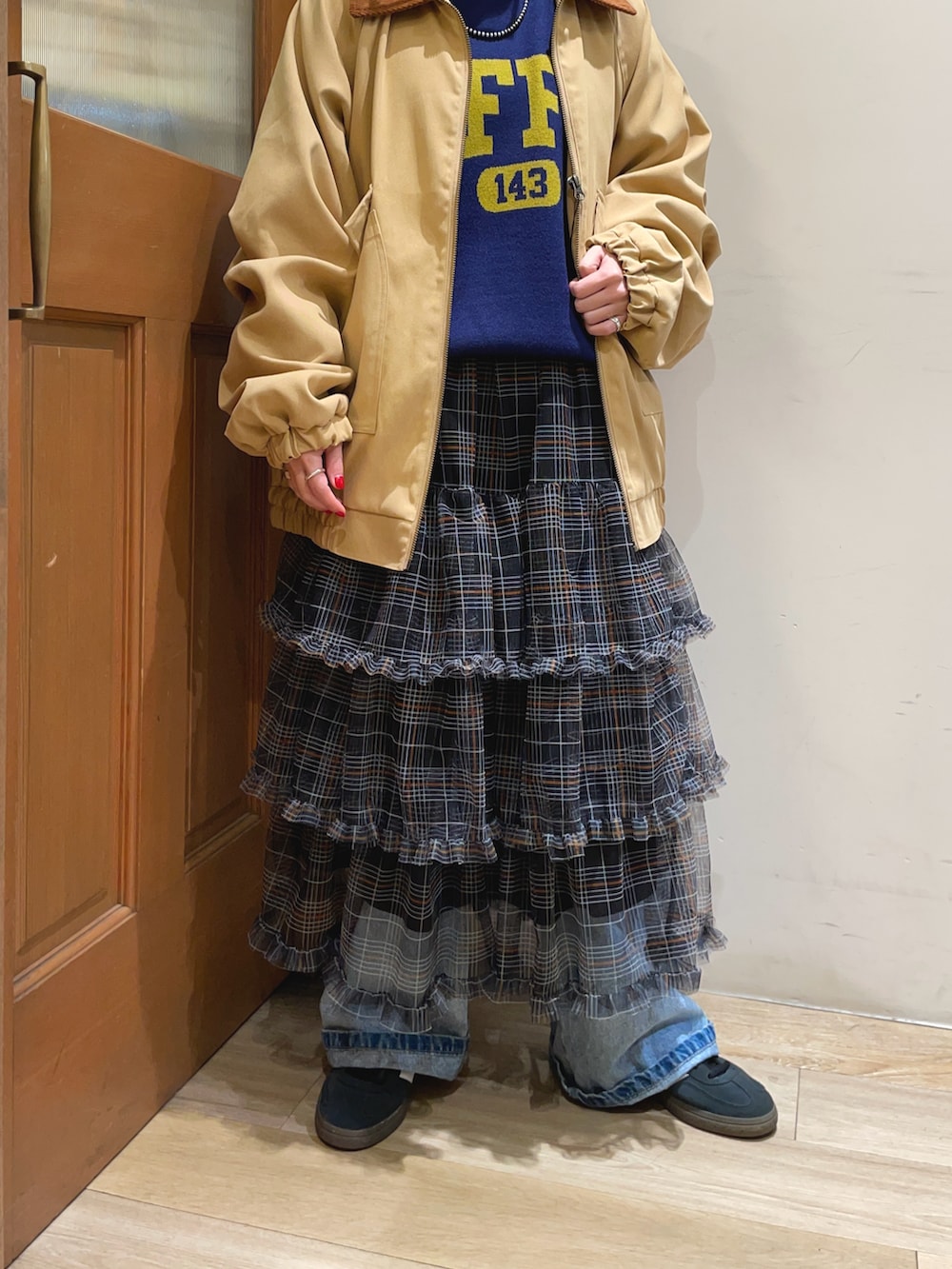 イエロー系のその他アウター、ブルー系のニット/セーター、ブラック系のスカートを着用したレディースの秋コーディネートの4枚目の写真