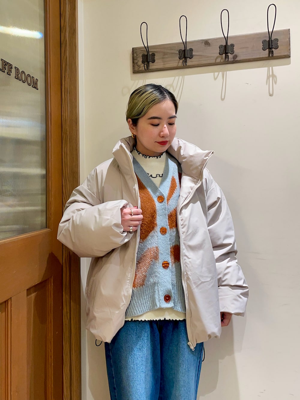 グレー系のダウンジャケット/コート、ブルー系のカーディガン/ボレロ、ホワイト系のニット/セーターを着用したレディースの冬コーディネートの3枚目の写真