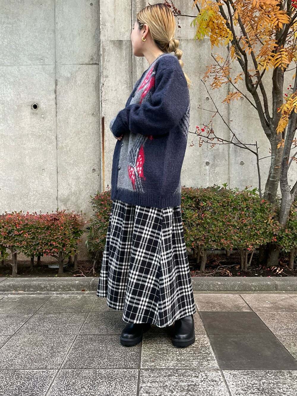 ホワイト系のスカート、ブラック系のブーツ、ブラック系のTシャツ/カットソーを着用したレディースの秋コーディネートの3枚目の写真