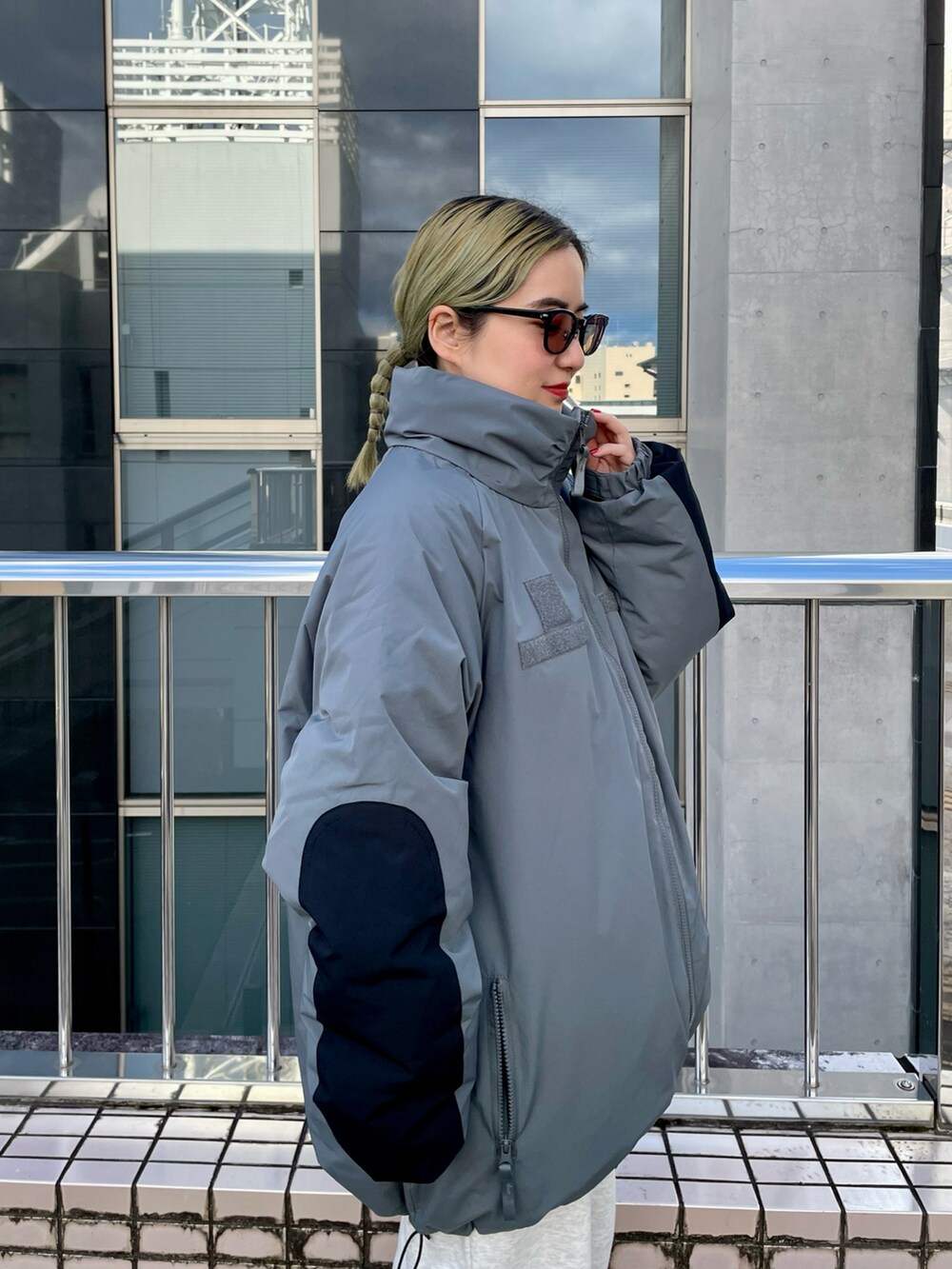 グレー系のダウンジャケット/コート、ホワイト系のニット/セーターを着用したレディースの秋コーディネートの5枚目の写真