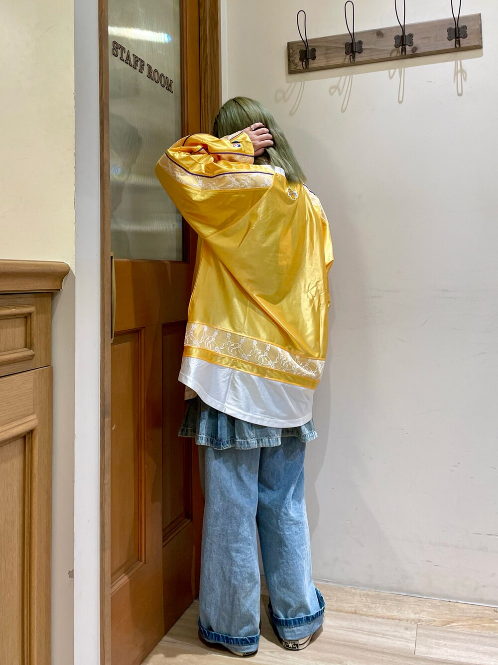 イエロー系のTシャツ/カットソー、ブラウン系のショルダーバッグ、ブルー系のデニムパンツを着用したレディースの秋コーディネートの2枚目の写真