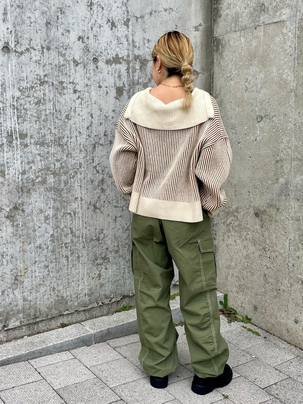 ベージュ系のニット/セーター、グリーン系のカーゴパンツ、ブラック系のブーツを着用したレディースの秋コーディネートの3枚目の写真