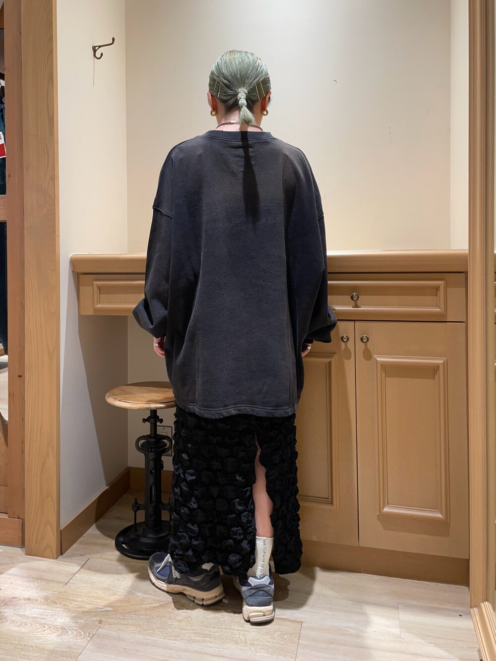 ブラック系のスウェット、ブラック系のスカートを着用したレディースの秋コーディネートの2枚目の写真