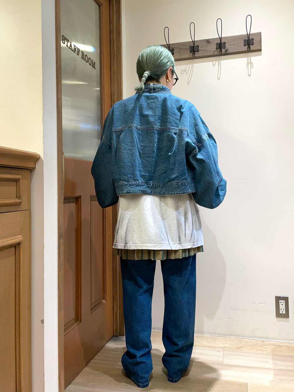 グレー系のTシャツ/カットソー、ブルー系のデニムパンツを着用したレディースの秋コーディネートの2枚目の写真