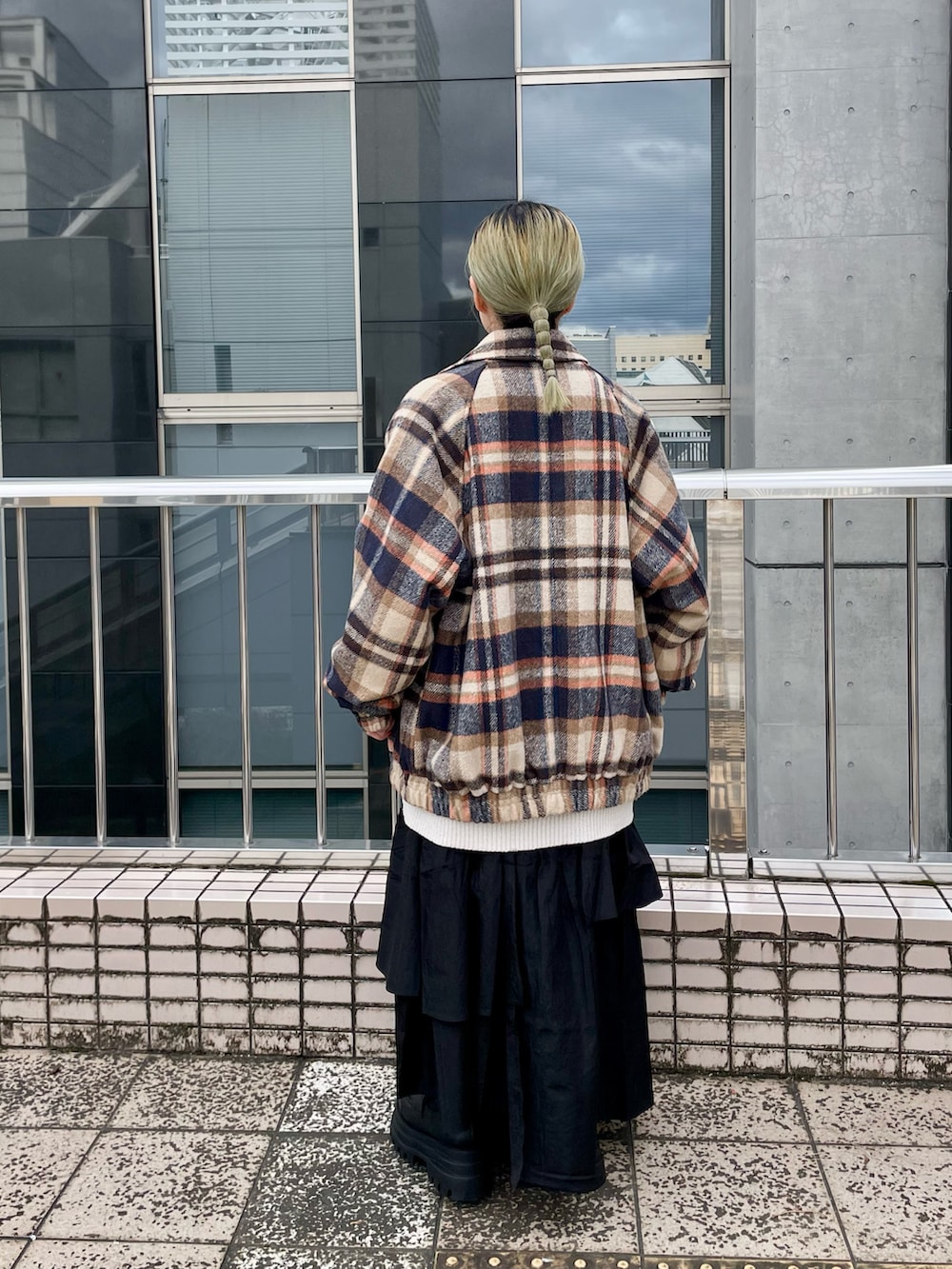 ホワイト系のニット/セーター、ブラウン系のブルゾン、ブラック系のスカートを着用したレディースの冬コーディネートの2枚目の写真