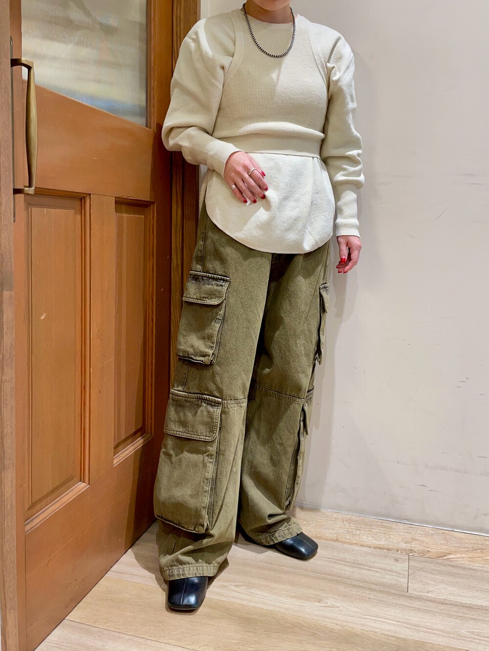 ホワイト系のニット/セーター、グリーン系のデニムパンツを着用したレディースの冬コーディネートの5枚目の写真