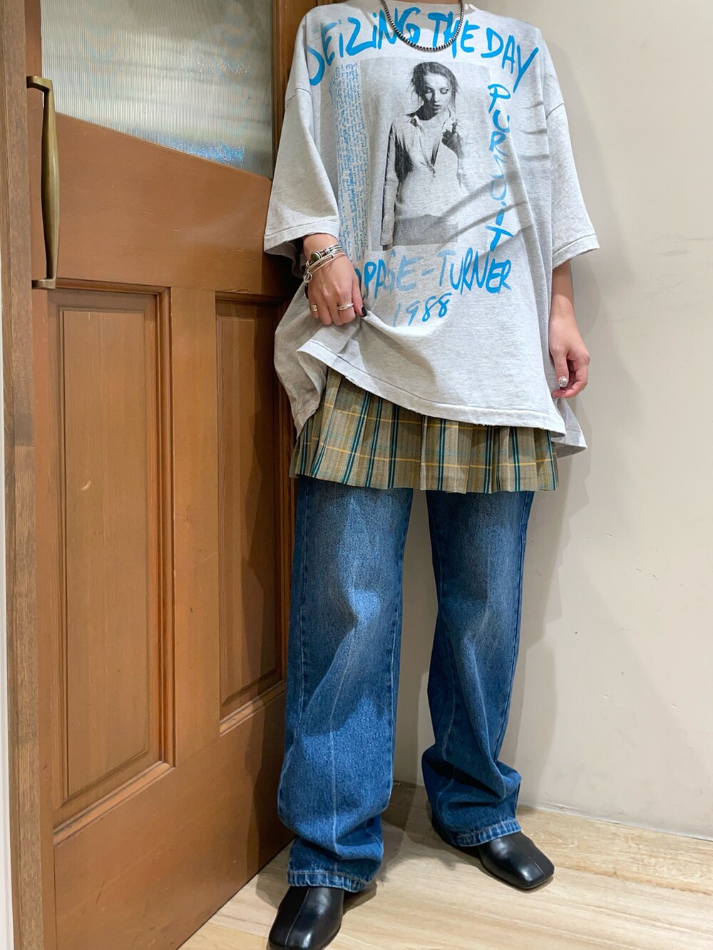 グレー系のTシャツ/カットソー、ブルー系のデニムパンツを着用したレディースの秋コーディネートの5枚目の写真