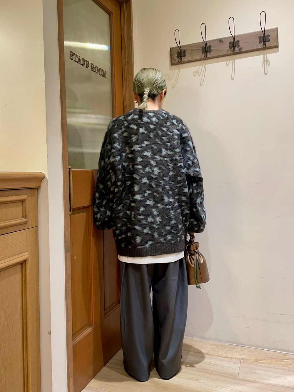 ベージュ系のカーディガン/ボレロ、グレー系のスラックス、ブラック系のハンドバッグを着用したレディースの秋コーディネートの2枚目の写真