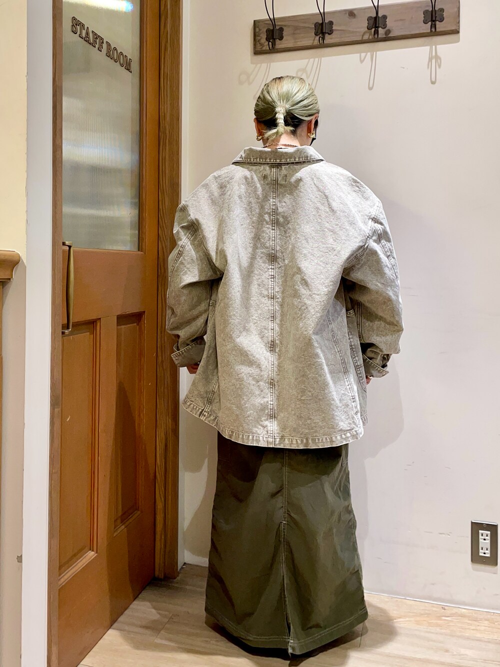 ピンク系のブルゾン、グリーン系のスカート、ブラック系のトップスを着用したレディースの秋コーディネートの2枚目の写真