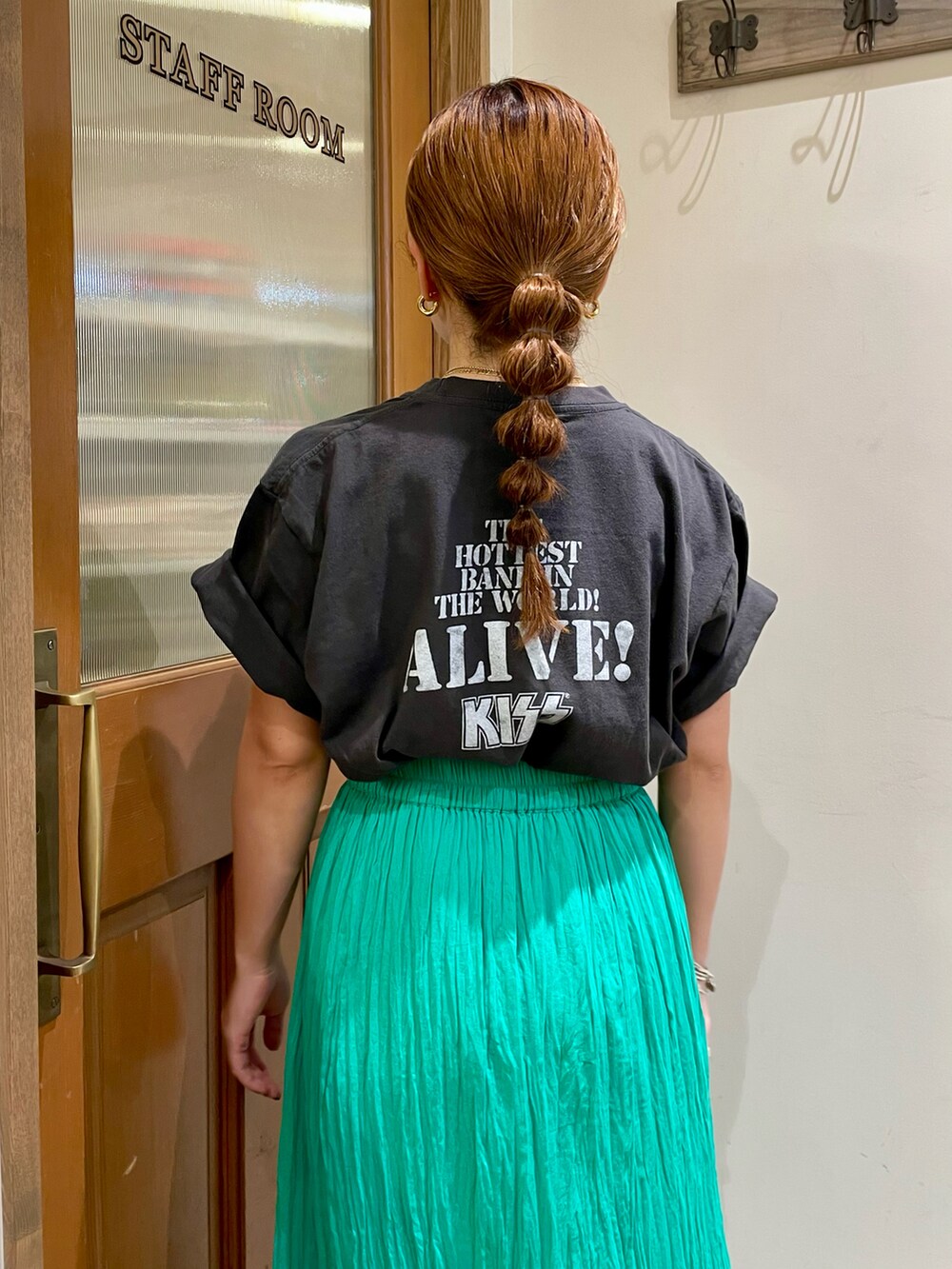 グリーン系のスカート、グレー系のTシャツ/カットソー、ブラック系のサンダルを着用したレディースの夏コーディネートの4枚目の写真