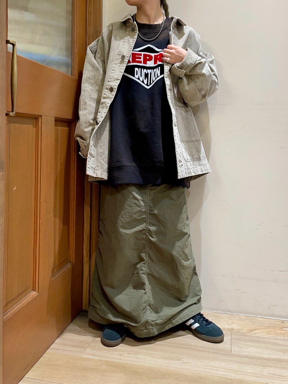 ピンク系のブルゾン、グリーン系のスカート、ブラック系のトップスを着用したレディースの秋コーディネートの4枚目の写真