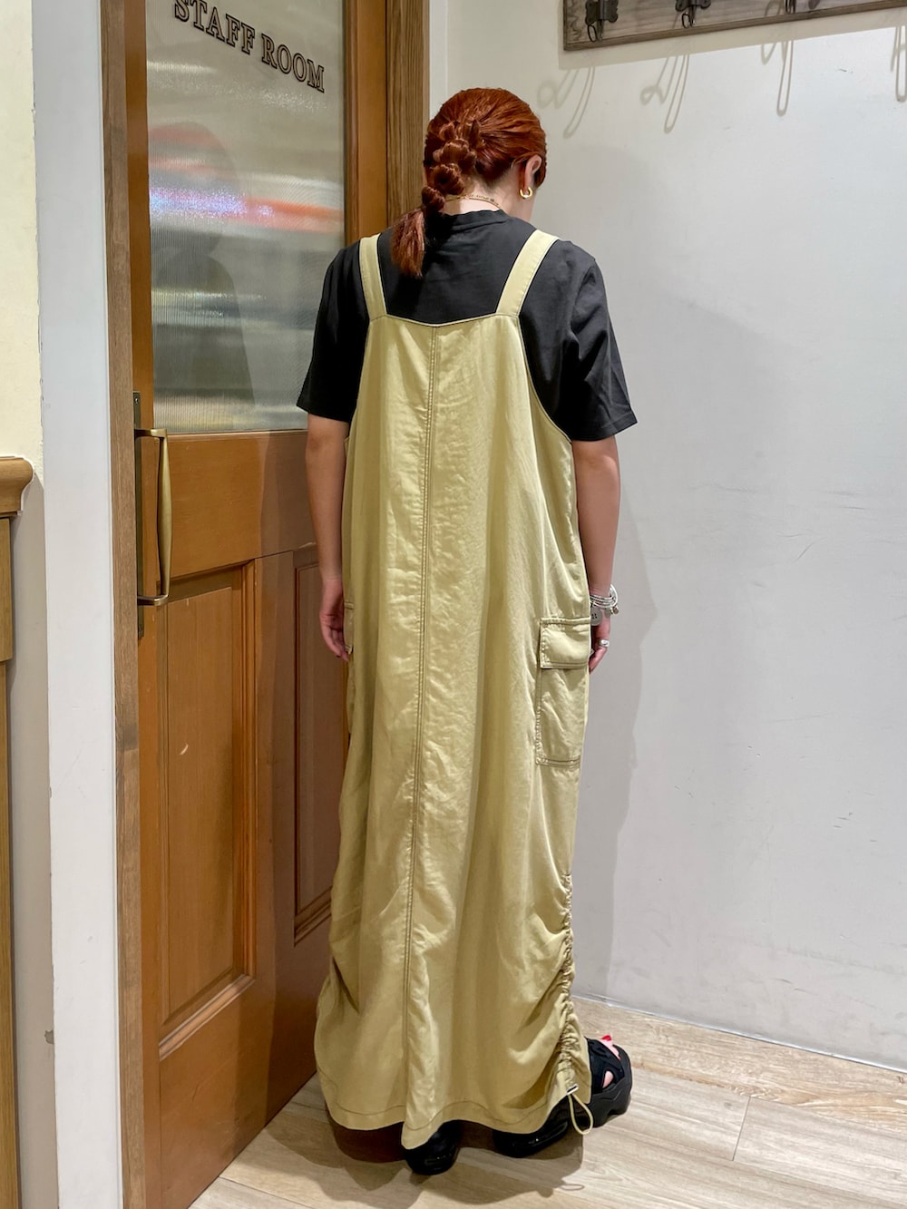 ブラック系のTシャツ/カットソー、ベージュ系のワンピース、ブラック系のシューズを着用したレディースの夏コーディネートの2枚目の写真