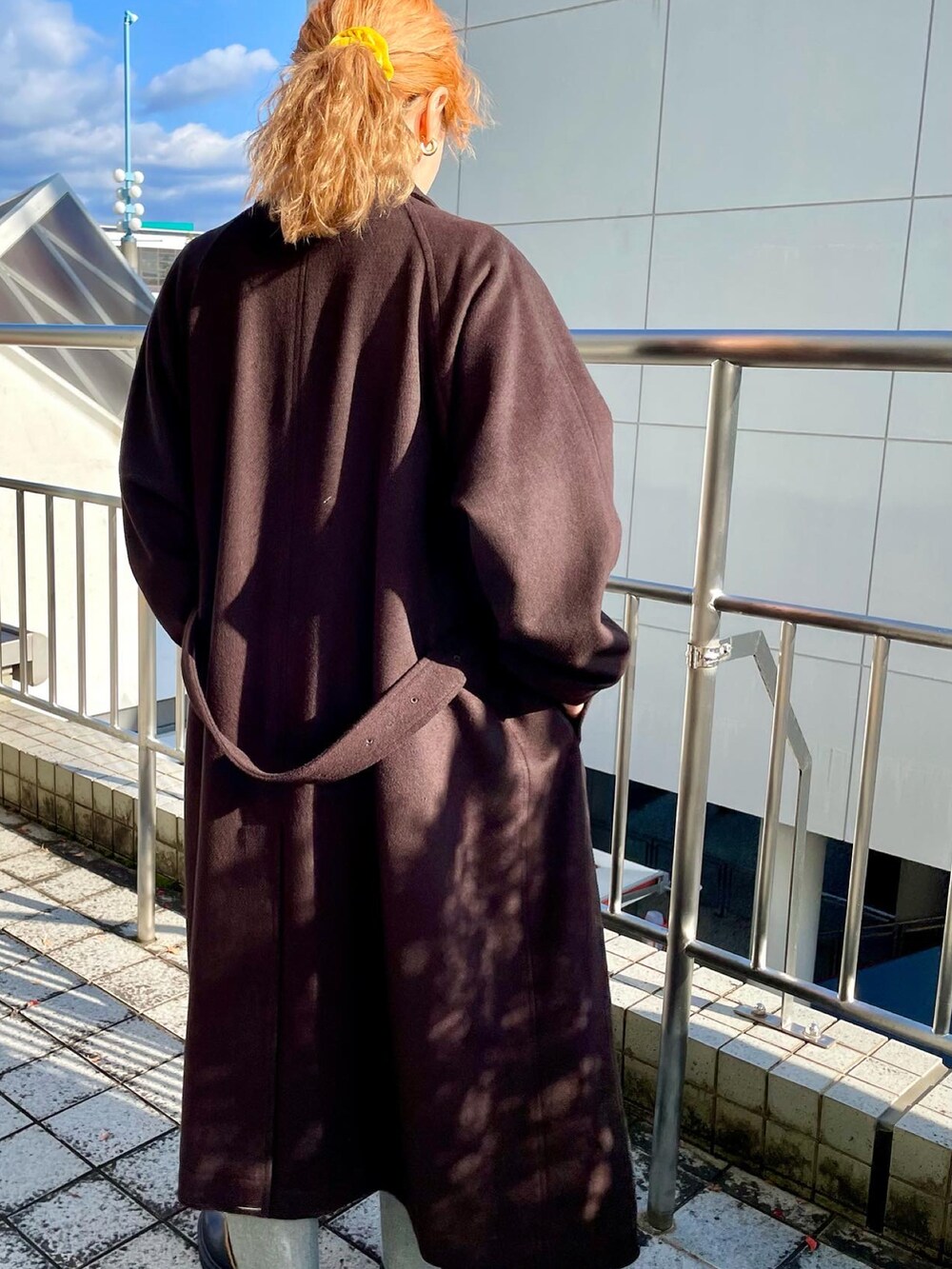 グリーン系のニット/セーター、ブルー系のデニムパンツ、ブラック系のブーツを着用したレディースの秋コーディネートの2枚目の写真