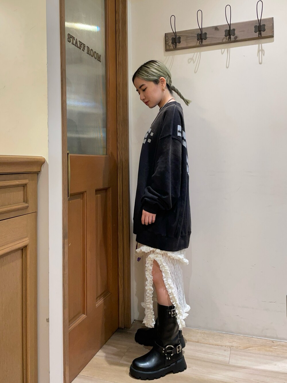 ブラック系のトップス、ホワイト系のスカート、ブラック系のブーツを着用したレディースの秋コーディネートの2枚目の写真