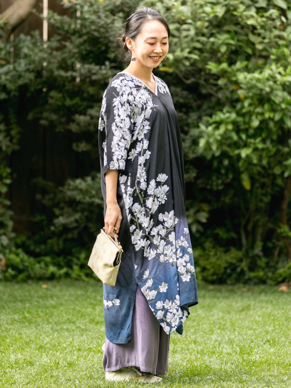 ブラック系のワンピース、グレー系のTシャツ/カットソー、ホワイト系のショルダーバッグを着用したレディースの春コーディネートの2枚目の写真