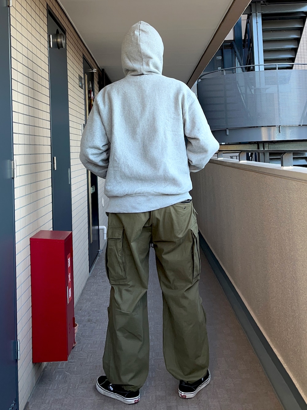 グレー系のパーカー、ブラック系のスタジャン、グリーン系のカーゴパンツを着用したメンズの冬コーディネートの4枚目の写真