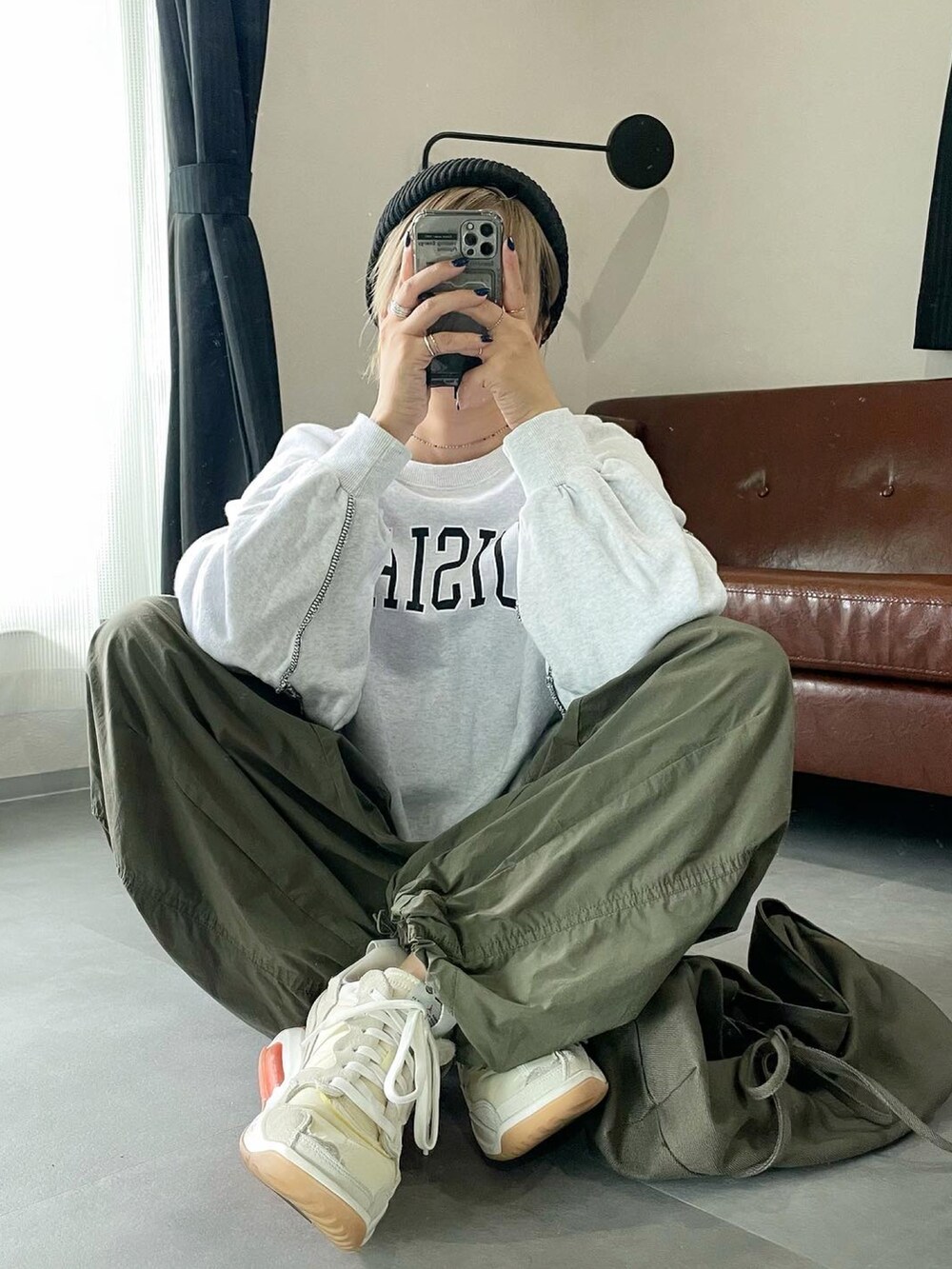 グレー系のスウェット、グリーン系のカーゴパンツ、ベージュ系のシューズを着用したレディースの春コーディネートの2枚目の写真