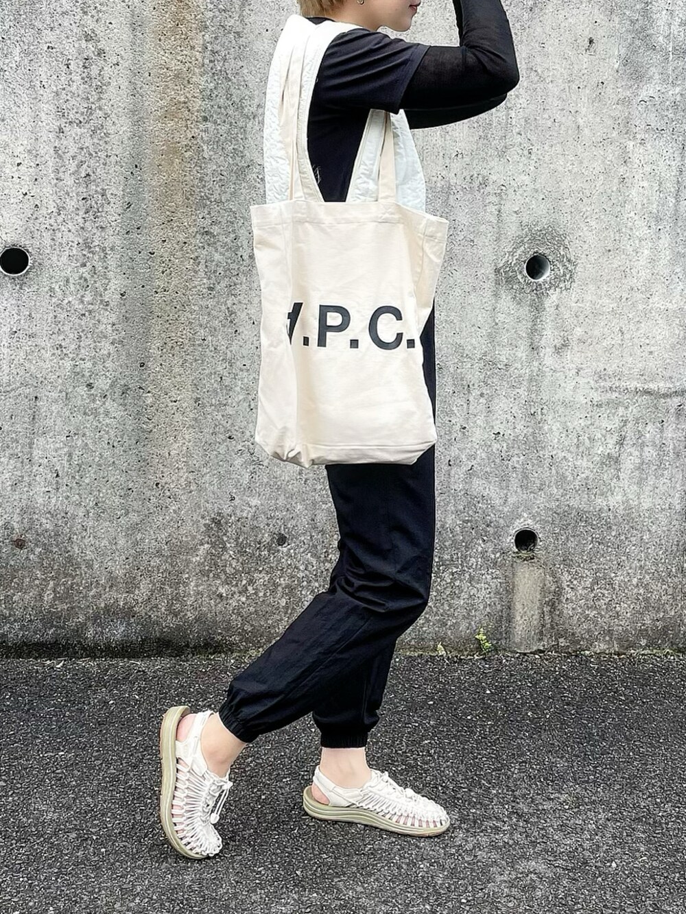 ブラック系のその他パンツ、ベージュ系のサンダル、ホワイト系のトートバッグを着用したレディースの春コーディネートの2枚目の写真