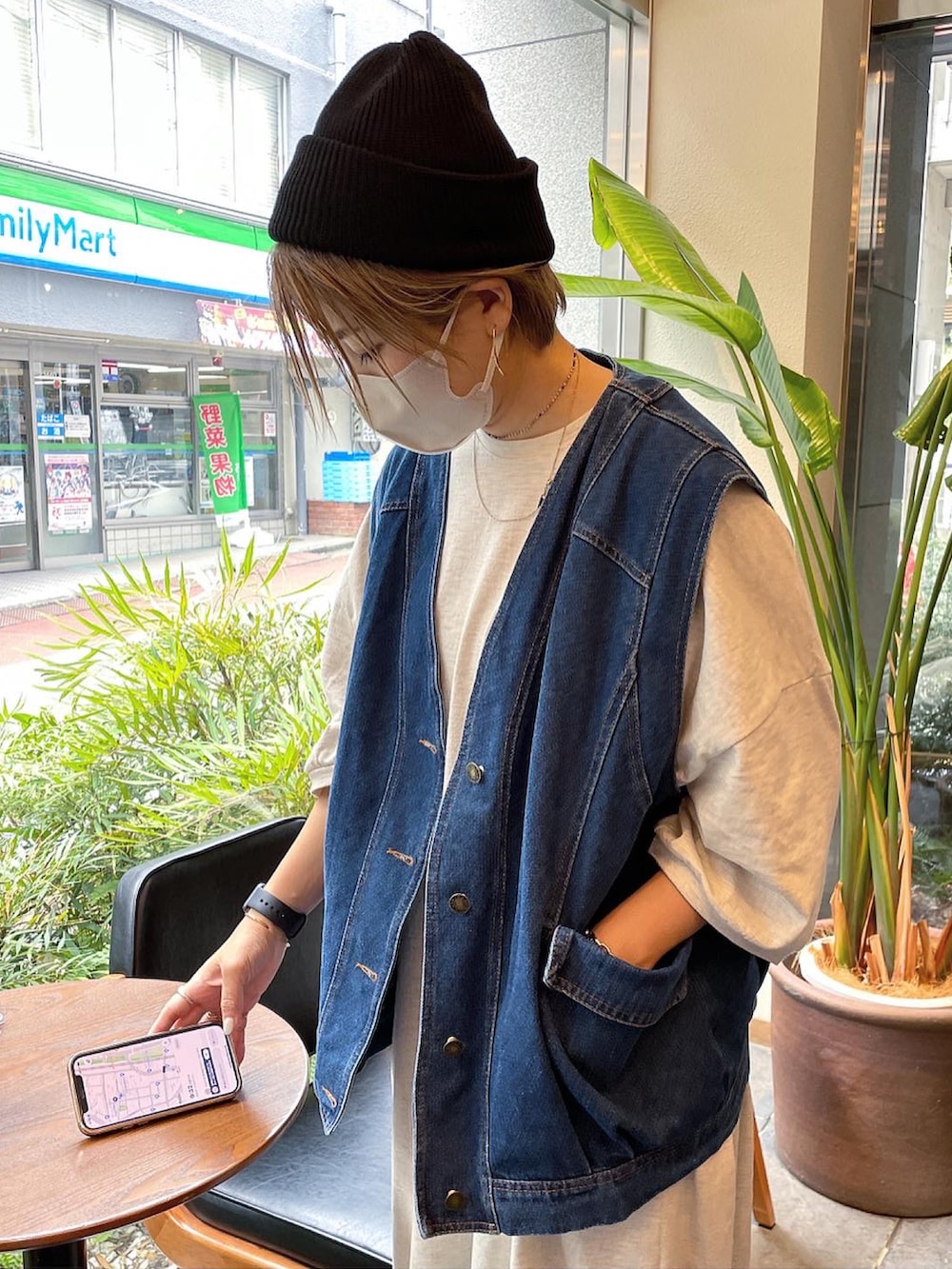 ブルー系のベスト、ホワイト系のショルダーバッグ、ベージュ系のサンダルを着用したレディースの秋コーディネートの2枚目の写真