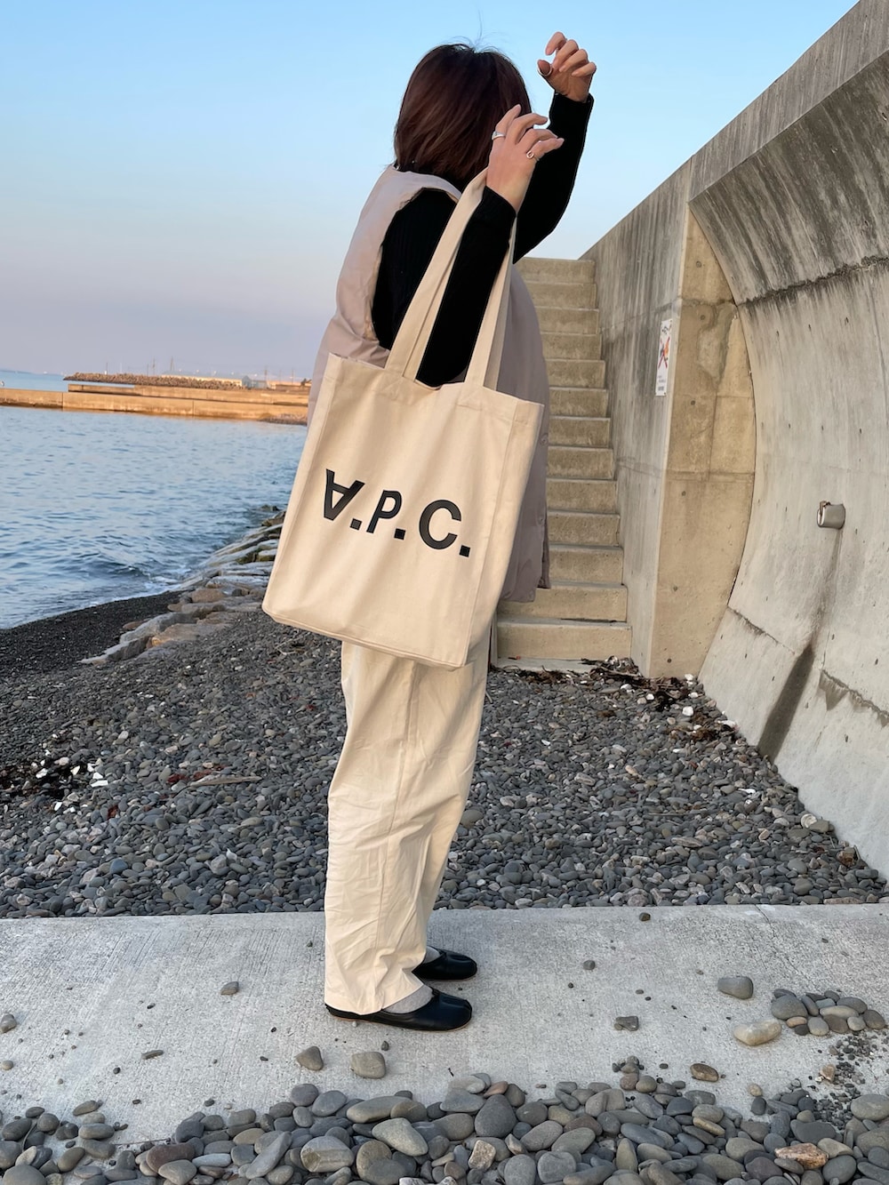 ホワイト系のその他パンツ、ベージュ系のダウンベスト、ブラック系のその他シューズを着用したレディースの春コーディネートの4枚目の写真