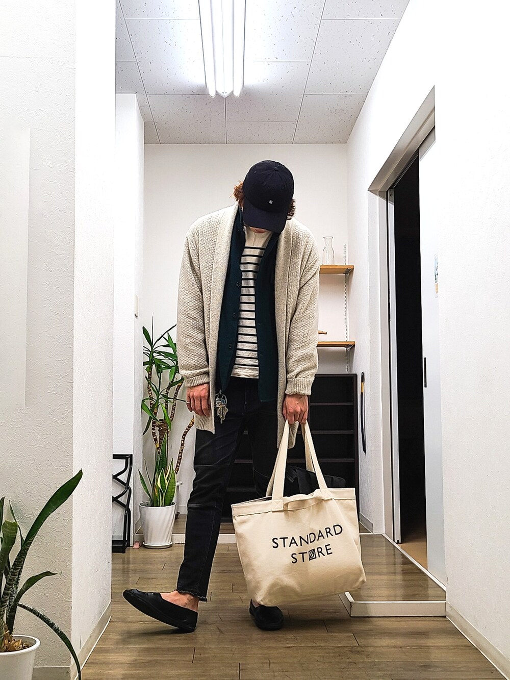 ベージュ系のトートバッグ、グレー系のカーディガン/ボレロ、その他のTシャツ/カットソーを着用したメンズの春コーディネートの2枚目の写真
