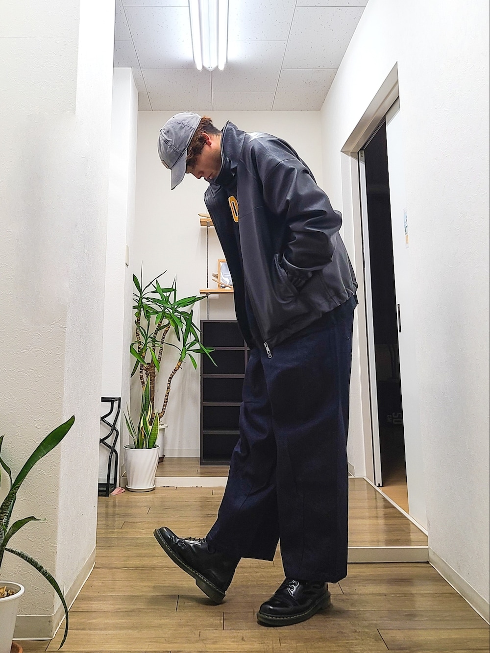 ブラック系のブーツ、ブルー系のデニムパンツ、ブルー系のスウェットを着用したメンズの春コーディネートの3枚目の写真