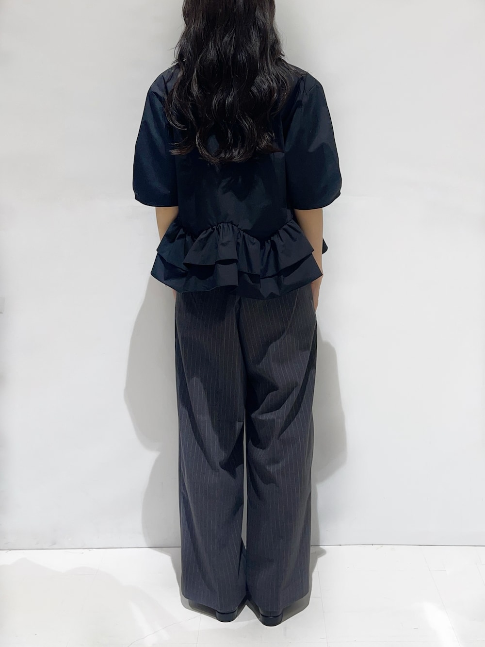 ブラック系のシャツ/ブラウス、グレー系のその他パンツ、ブラック系のパンプスを着用したレディースの秋コーディネートの3枚目の写真