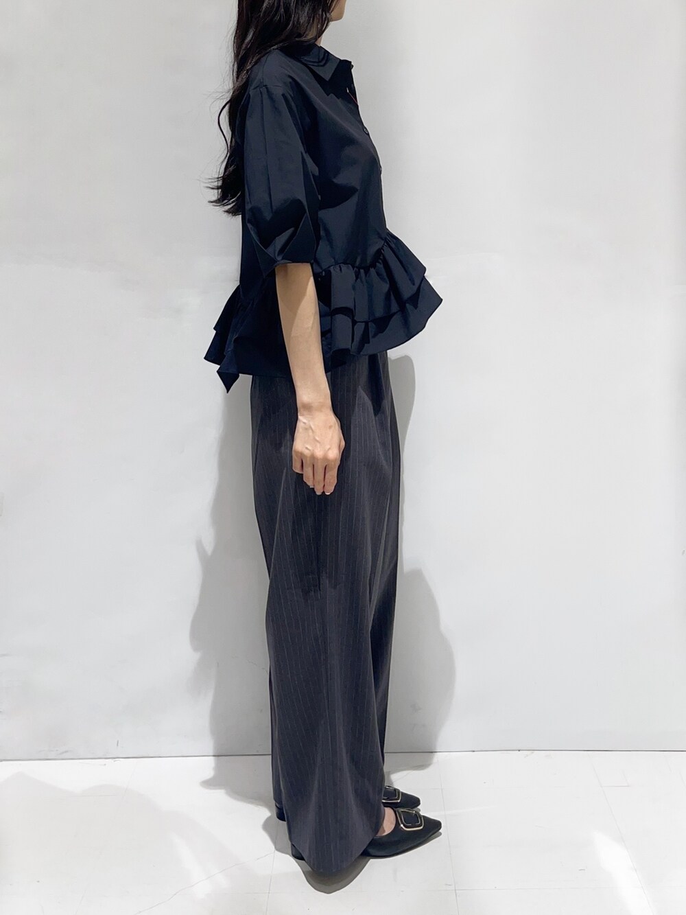 ブラック系のシャツ/ブラウス、グレー系のその他パンツ、ブラック系のパンプスを着用したレディースの秋コーディネートの2枚目の写真