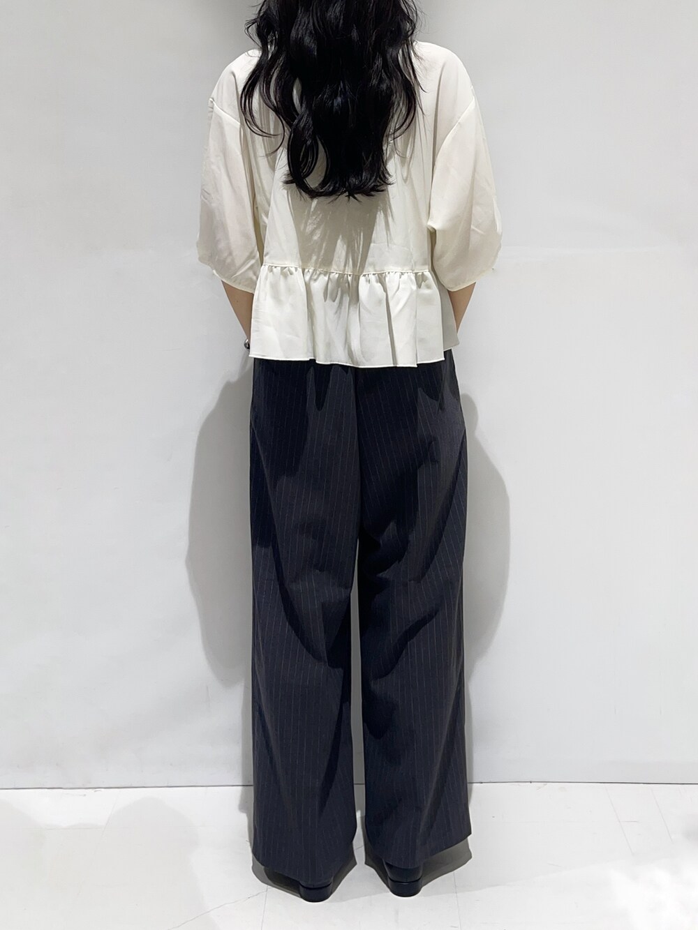 ホワイト系のシャツ/ブラウス、グレー系のその他パンツ、ブラック系のパンプスを着用したレディースの秋コーディネートの3枚目の写真