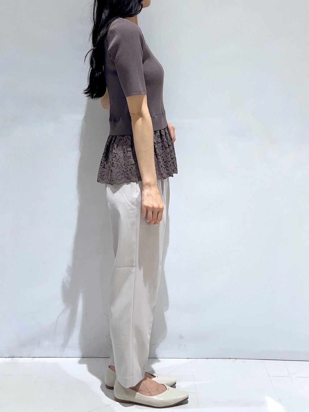 ブラウン系のニット/セーター、ベージュ系のその他パンツ、ホワイト系のパンプスを着用したレディースの秋コーディネートの2枚目の写真